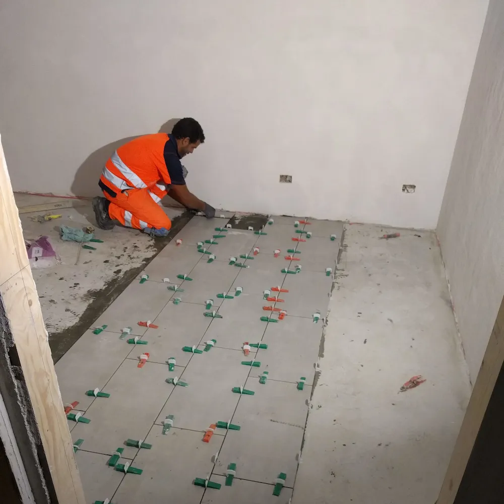 Posa di piastrelle in gres porcellanato su pavimento interno